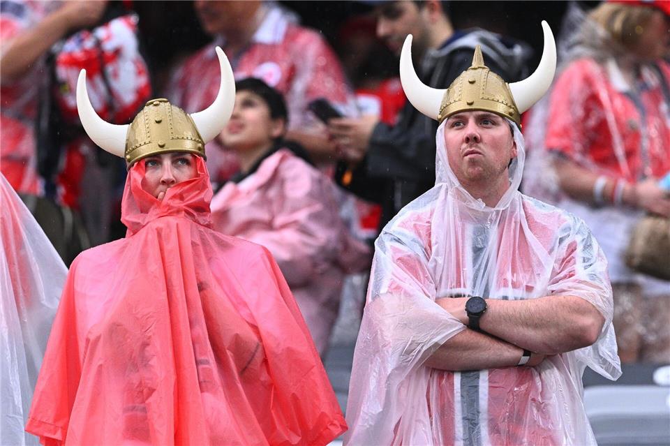 Norwegische Fans mit Regenschutz stehen vor dem Spiel im Stadion.Tom Weller/dpa