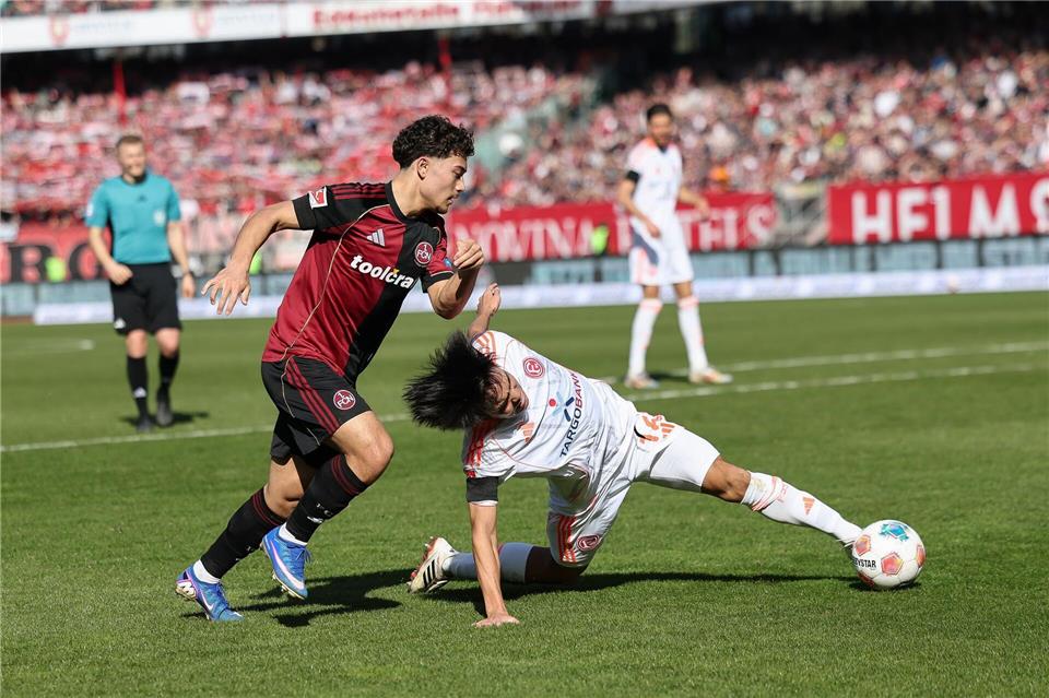 Nürnbergs Youngster Justin von der Hitz (l) im Zweikampf mit dem Düsseldorfer Satoshi Tanaka.Daniel Löb/dpa