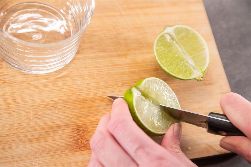 Nun die Limettenhälften neben dem Strunk noch einmal halbieren.Christin Klose/dpa-tmn