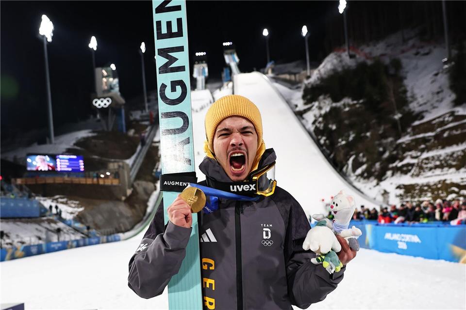 Olympiasieger Philipp Raimund jubelt mit seiner Goldmedaille über den ersten Platz bei den Olympischen Winterspielen Mailand Cortina 2026.Daniel Karmann/dpa