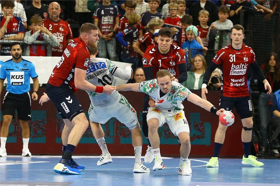Omar Ingi Magnusson (SC Magdeburg, M) verliert im Zweikampf gegen Blaz Blagotinsek (SG Flensburg-Handewitt) und Marko Grgic (SG Flensburg-Handewitt) den Ball.Michael Hundt/dpa