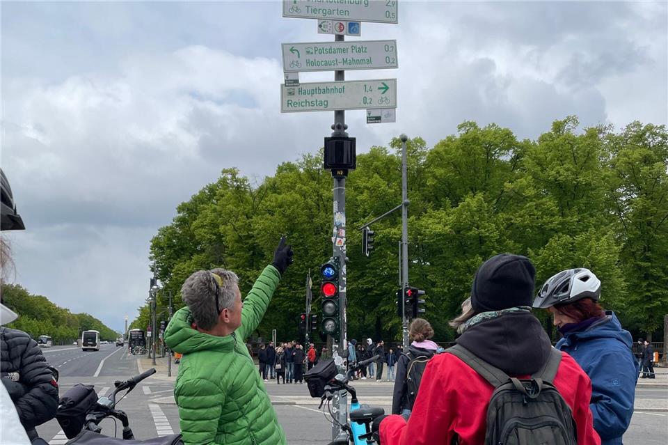 Orientierung ist gefragt: Die Reisegruppe vor Wegweisern in Berlin.Anita Arneitz/dpa-tmn