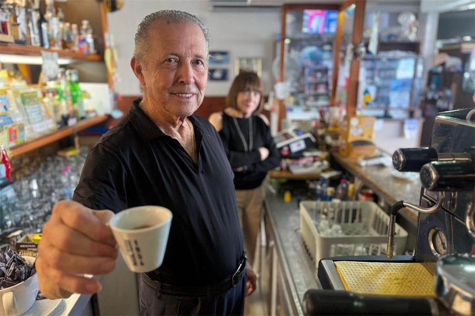 Orlando Paldino zeigt stolz eine Tasse Espresso für 70 Cent. Im Hintergrund steht seine Frau Rosina Furiati.Christoph Sator/dpa
