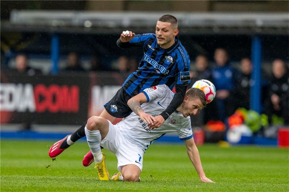 Paderborns Florent Muslija (l) und Rostocks Nico Neidhart kämpfen um den Ball.