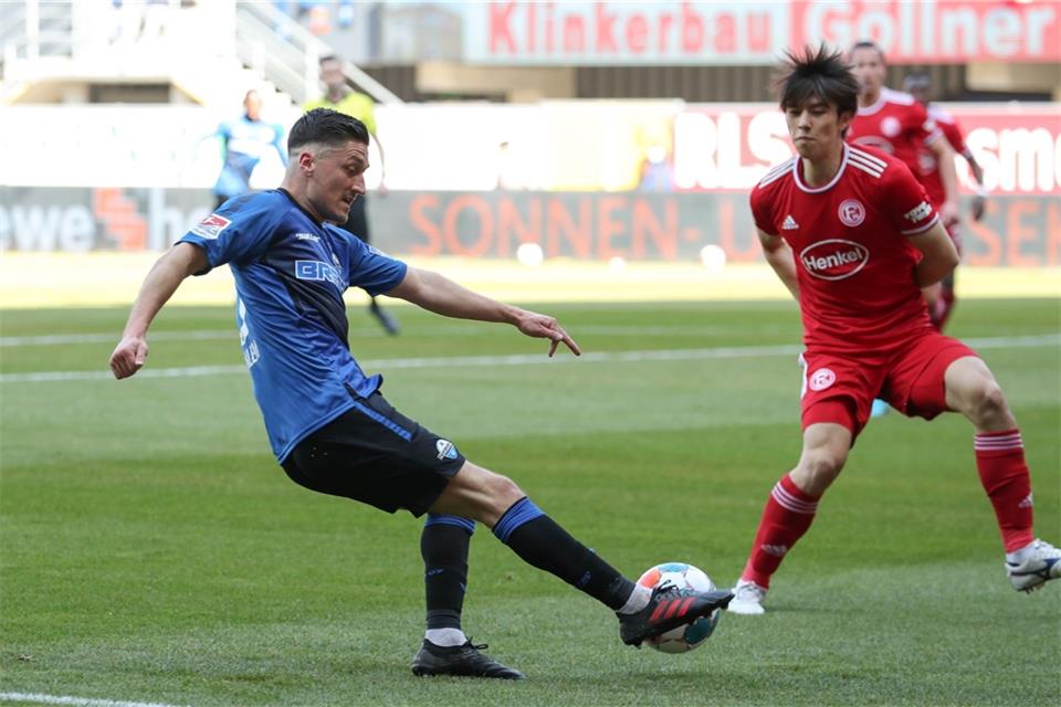Paderborns Marcel Mehlem (l) im Kampf um den Ball mit Düsseldorfs Ao Tanaka (r).