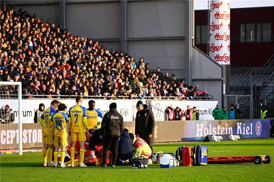 Paderborns Spieler Calvin Brackelmann wird auf dem Rasen von Sanitätern behandelt.Gregor Fischer/dpa