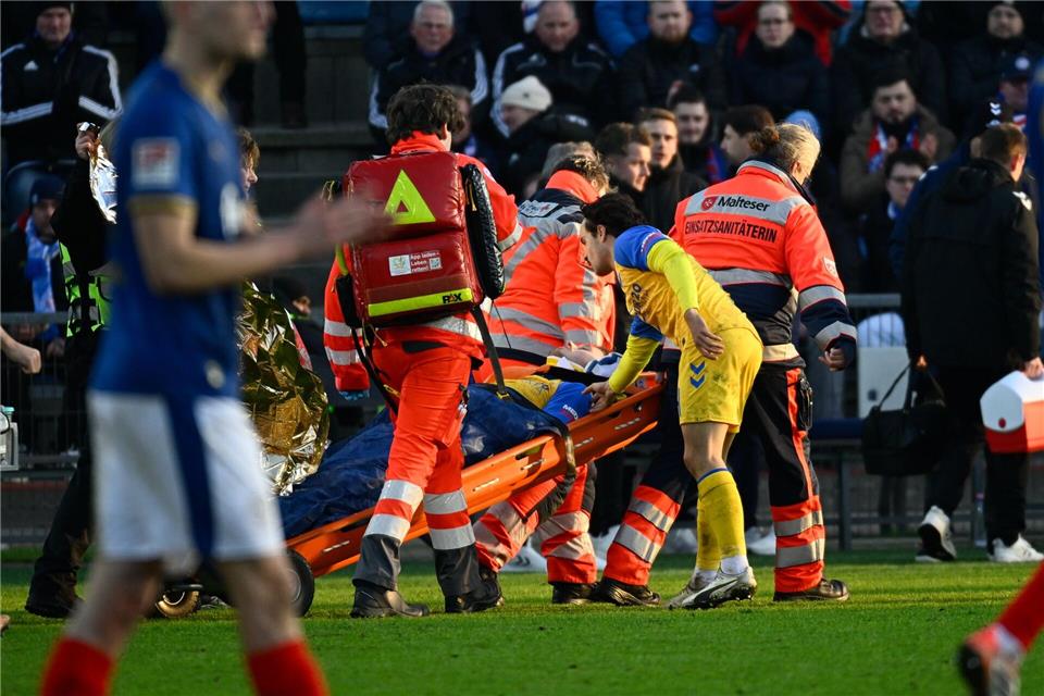 Paderborns Spieler Calvin Brackelmann wird nach einer Verletzung von Sanitätern auf einer Trage vom Spielfeld gebracht.Gregor Fischer/dpa