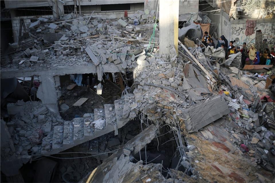 Palästinenser betrachten die Zerstörung nach einem israelischen Angriff.
