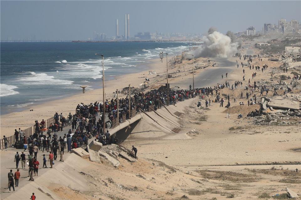 Bilder des Tages Palästinenser gehen entlang der Küstenstraße in der Nähe von Wadi Gaza im zentralen Gazastreifen in Richtung des nördlichen Gazastreifens.Yousef Al Zanoun/AP/dpa