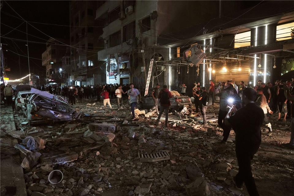 Palästinenser inspizieren den Ort eines israelischen Luftangriffs in Gaza.Jehad Alshrafi/AP/dpa