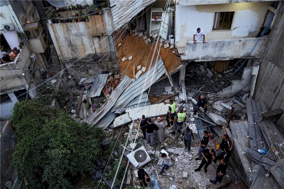 Wieder Unruhen: Israel greift an Gaza-Grenze Hamas-Posten an Palästinenser inspizieren nach dem Einsatz der israelischen Armee ein beschädigtes Gebäude.