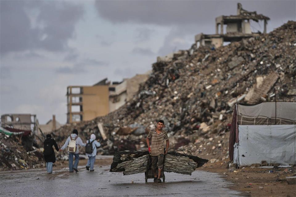 Palästinenser trägt Bleche durch Kriegsschutt in GazaJehad Alshrafi/AP/dpa