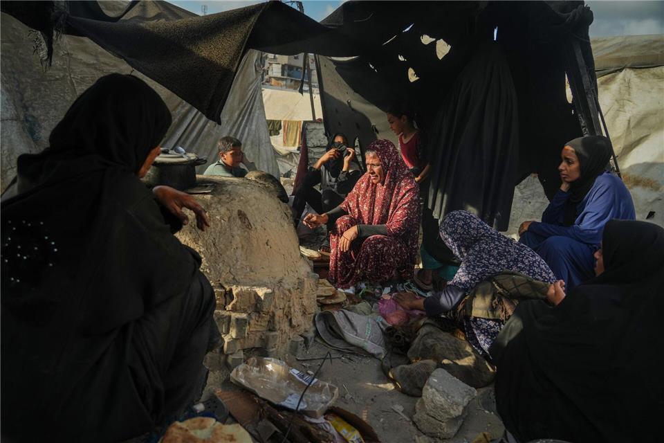 Palästinensische Frauen backen Brot in Notunterkunft. Jehad Alshrafi/AP/dpa