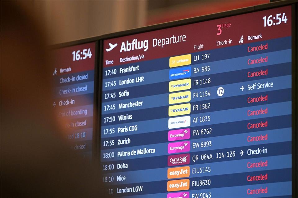 Passagiere blicken auf eine Anzeigetafel am Hauptstadtflughafen BER.Michael Bahlo/dpa