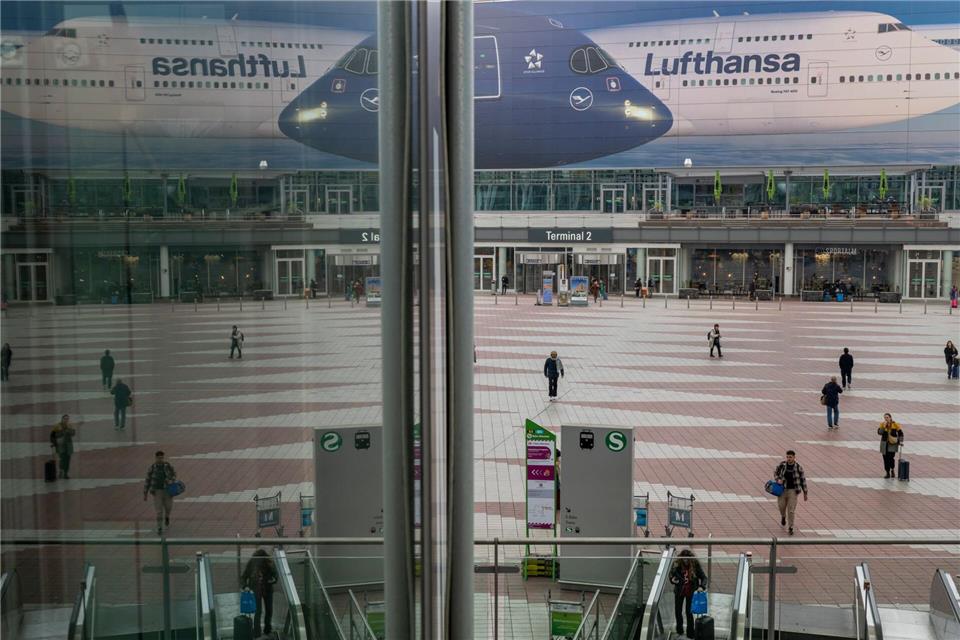 Passanten gehen am Morgen zum Flughafen München. Die Pilotengewerkschaft Vereinigung Cockpit hat für Montag und Dienstag zu Arbeitsniederlegungen bei der Lufthansa und mehreren Tochtergesellschaften aufgerufen.Peter Kneffel/dpa