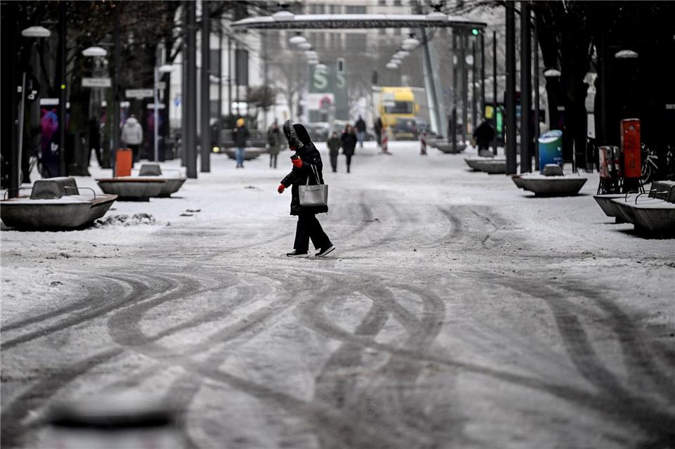 Passanten gehen durch Schneematsch am Potsdamer Platz.Britta Pedersen/dpa