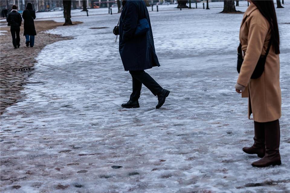 Passanten gehen vor dem Eingang zum Schloss Charlottenburg spazieren.Carsten Koall/dpa