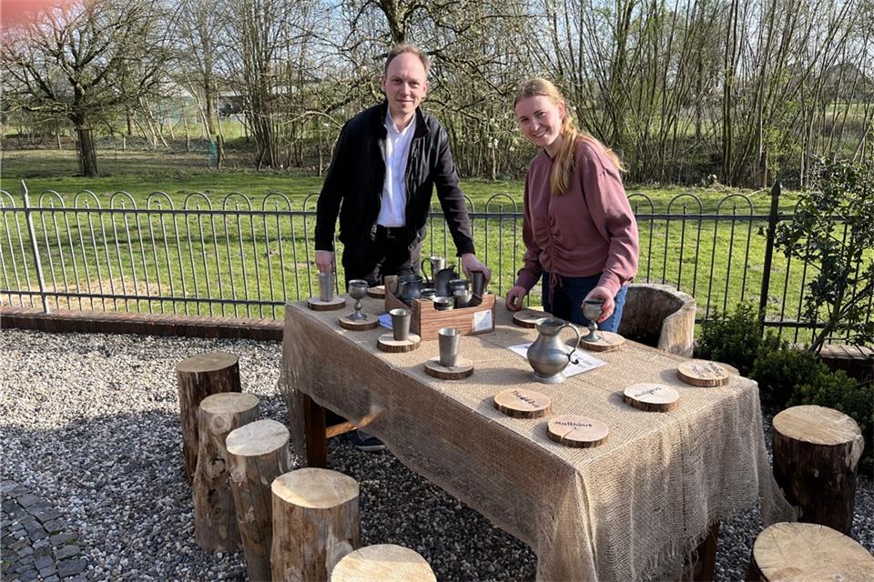 Pastor Fabian Tilling und Katharina Anschlag bereiten den Tisch vor, der die Station des letzten Abendmahls im Ostergarten an der St.-Marien-Kirche symbolisiert.
