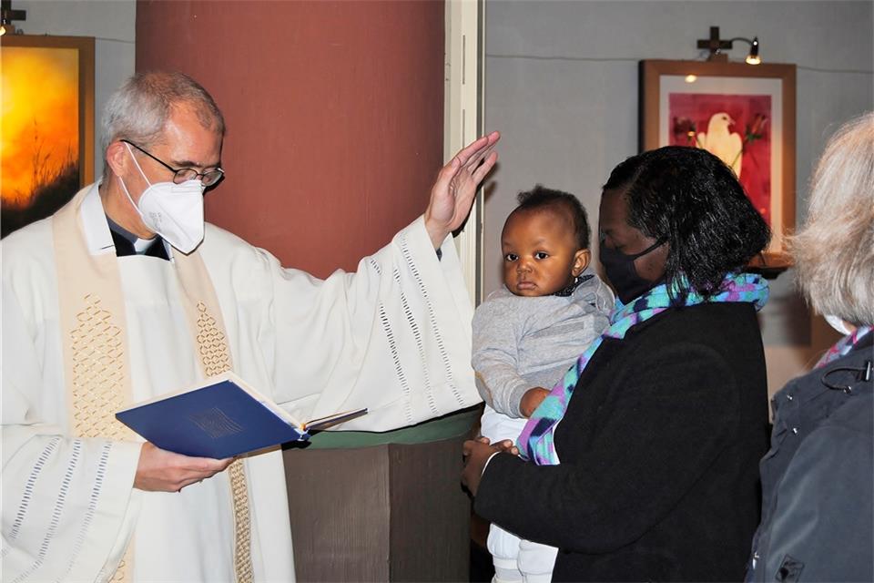 Pastor Michael Kenkel hat Amge-Pierre getauft, rechts seine Mutter Christell. Die beiden Flüchtlinge kommen aus Kamerun.