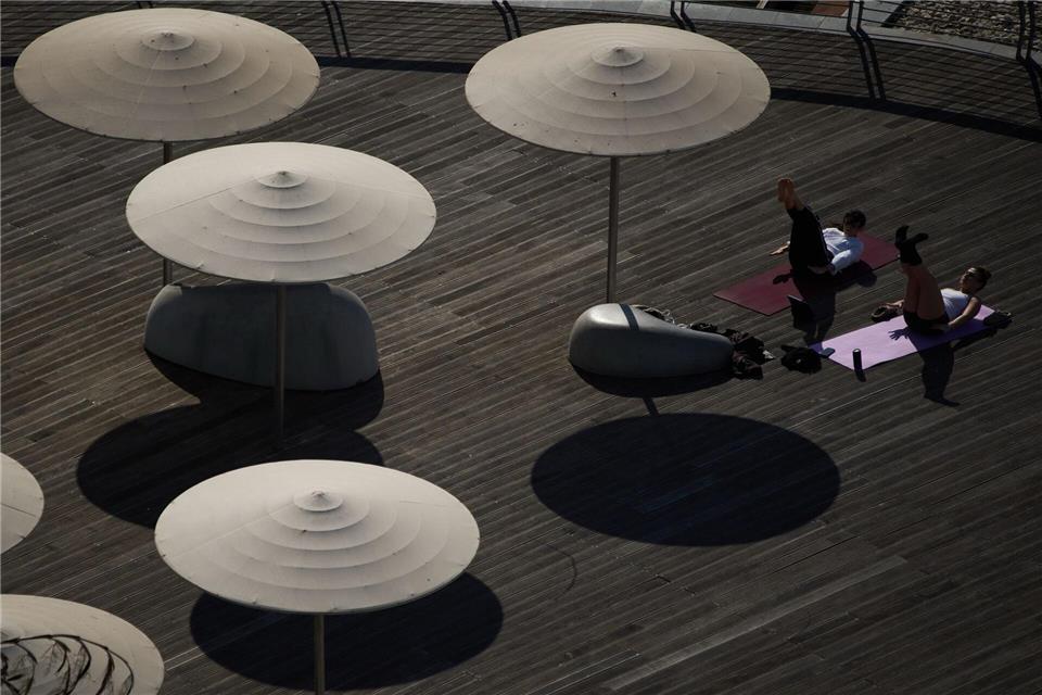 Personen trainieren am Strand von Tel Aviv.Leo Correa/AP/dpa