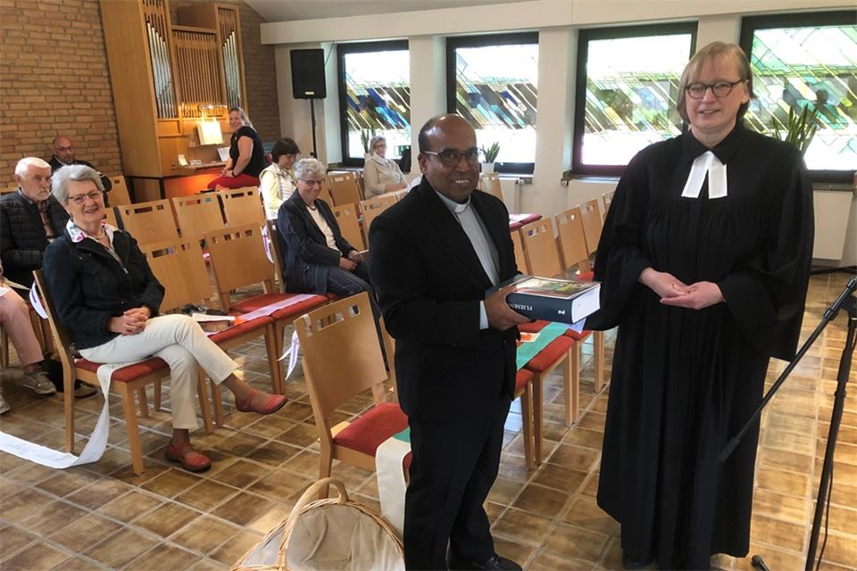 Pfarrerin Barbara Werschkull hat Pastor Johnsun eine Fliesenbibel überreicht.