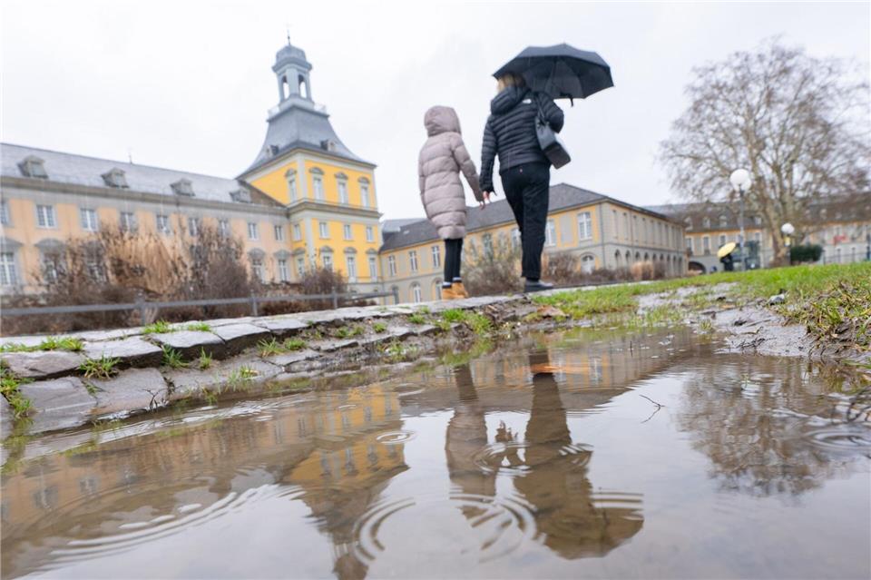 Pfützen und Regenschirm: Auch in den kommenden Tagen müssen sich die Menschen in NRW auf Regen einstellen.Benjamin Westhoff/dpa