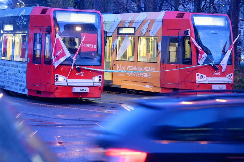 Plakate an einer Straßenbahn der Kölner Verkehrsbetriebe wiesen auf den Warnstreik hin. Henning Kaiser/dpa