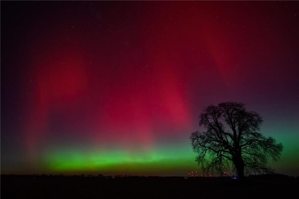 Polarlichter leuchten am Nachthimmel über der Landschaft im östlichen Brandenburg.Patrick Pleul/dpa