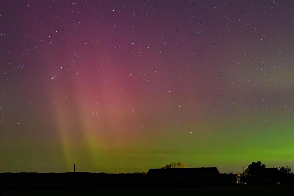 Bilder des Tages Polarlichter und der Komet Lemmon „C/2025 A6“ (Bildmitte links) leuchten am Nachthimmel über der Landschaft im östlichen Brandenburg. Patrick Pleul/dpa
