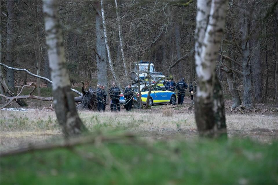 Tote Frau an Waldweg in Ennepetal entdeckt Polizeibeamte stehen mit mehreren Einsatzfahrzeugen nahe eines Tatortes in einem Wald.