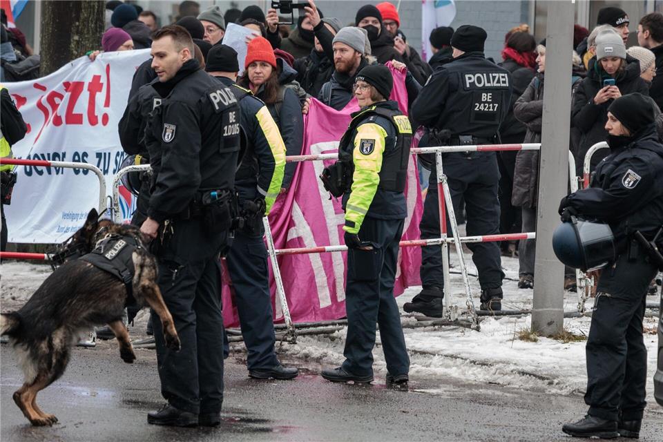Polizisten beobachten den Protest, die AfD-Landeszentrale wird mit Absperrgittern abgeschirmt.Carsten Koall/dpa