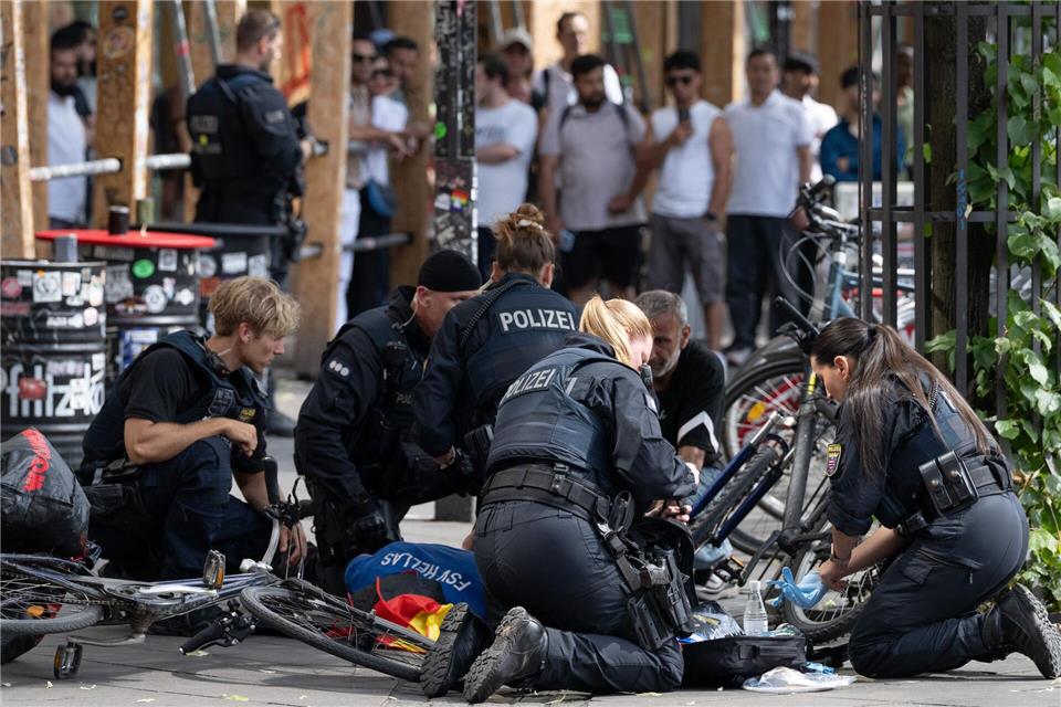 Polizisten knien in der Nähe des Frankfurter Hauptbahnhofs am Boden und kümmern sich um einen Verletzten. Boris Roessler/dpa