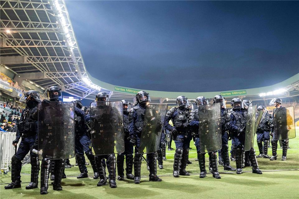 Polizisten sichern das Spielfeld im Stadion des FC Nantes ab.Sebastien Salom-Gomis/AFP/dpa