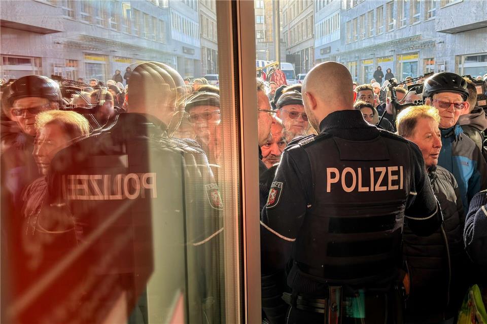 Polizisten sichern den Eingang der Sparkassenfiliale in Gelsenkirchen, vor der viele besorgte Kunde stehen und Informationen nach dem Einbruch in den Tresorraum verlangen.Christoph Reichwein/dpa