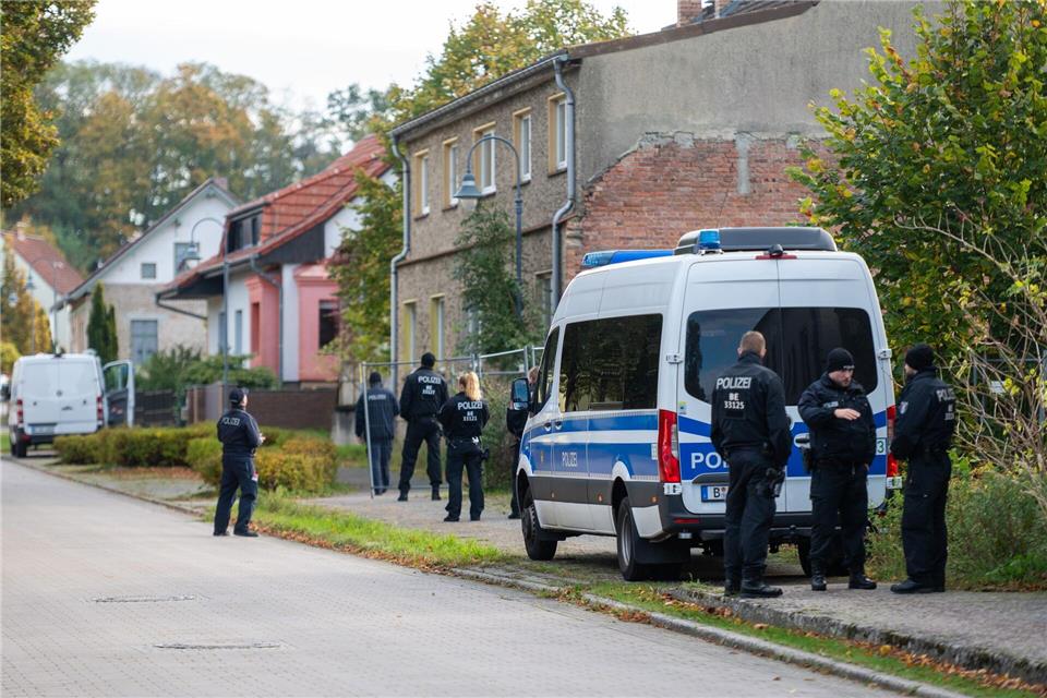Polizisten stehen vor einem Grundstück in Tauche.Christophe Gateau/dpa
