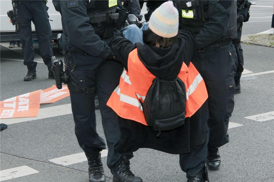 Polizisten tragen einen Menschen bei einer Demonstration von der Straße. (Archivbild) Paul Zinken/dpa