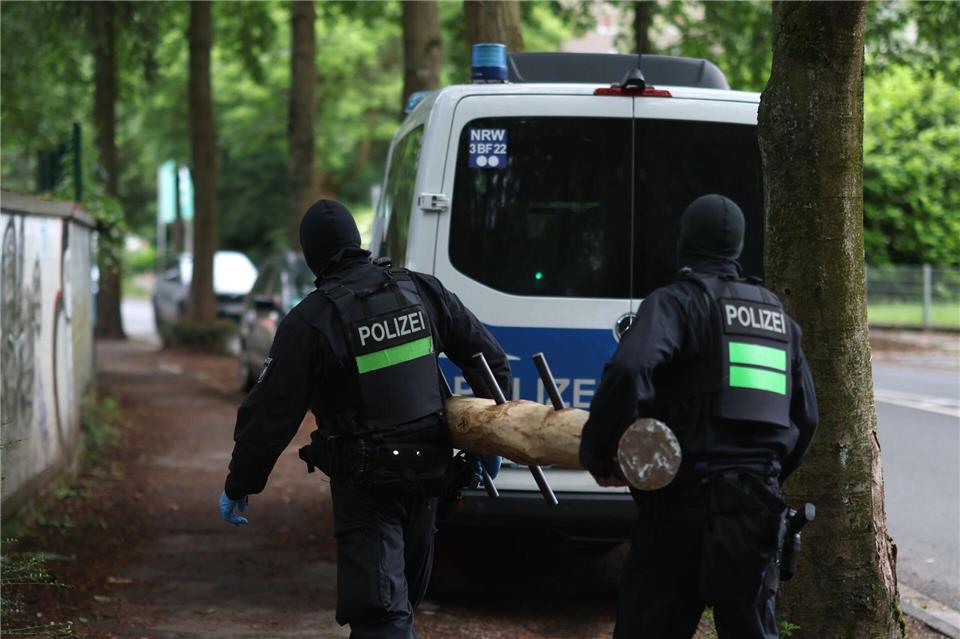 Polizisten tragen einen Rammbock.Christoph Reichwein/dpa