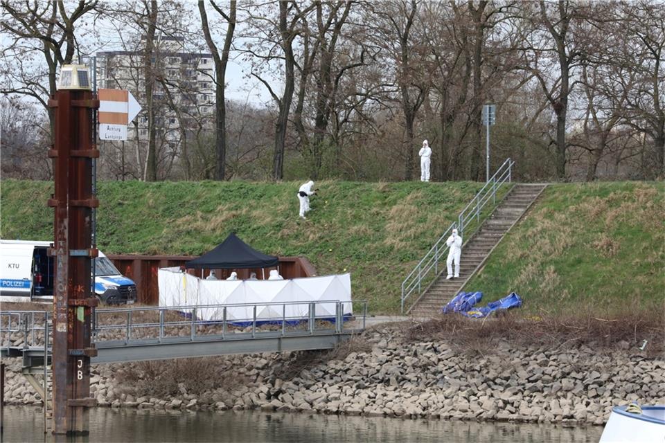Polizisten untersuchen am Fundort einer Leiche die Umgebung. Am Hafen in Köln ist am Sonntagmorgen ein 15-Jähriger tot an einer Landzunge gefunden worden.