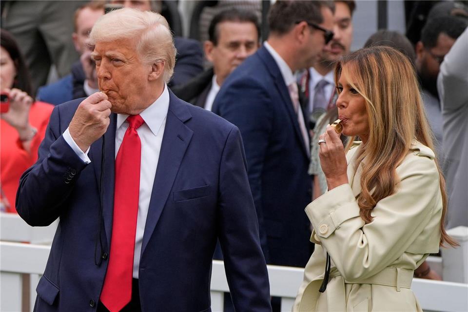 Präsident Donald Trump und Melania Trump blasen während des White House Easter Egg Roll in Trillerpfeifen.Alex Brandon/AP/dpa