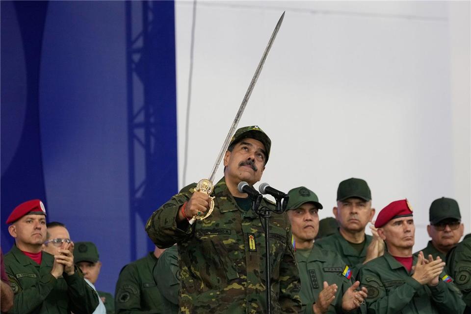 Präsident Nicolas Maduro schwingt ein Schwert.Ariana Cubillos/AP/dpa