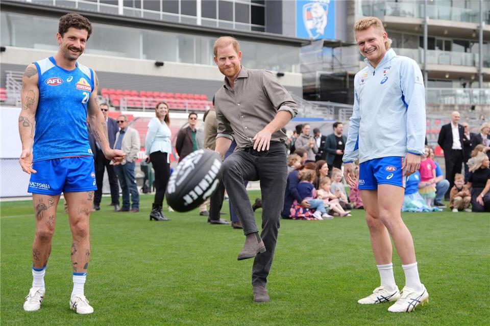 Prinz Harry (M), Herzog von Sussex, kickt einen Football.Jonathan Brady/Pool PA/AP/dpa