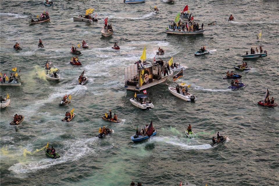 Pro-iranische Hisbollah-Anhänger auf kleinen Booten paradieren in der Nähe des libanesischen Taubenfelsens während einer Veranstaltung zum ersten Jahrestag der Tötung von Parteichef Hassan Nasrallah.Marwan Naamani/dpa