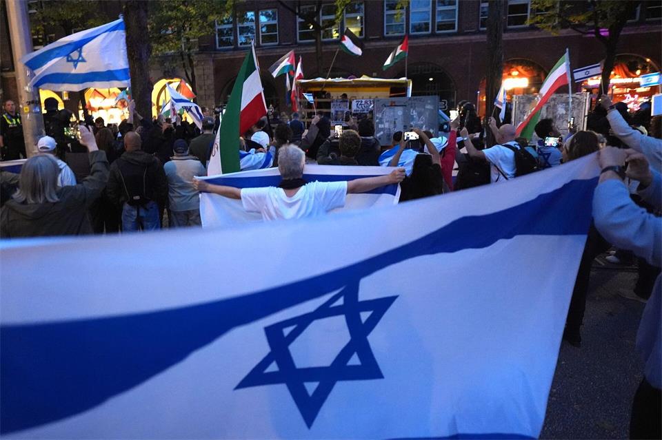 Proisraelische Demonstranten zeigen Flagge, während ein propalästinensischer Demonstrationszug durch den Stadtteil St. Georg geht. Marcus Brandt/dpa