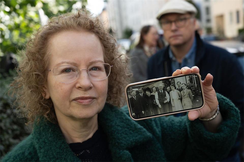 Rachel van Elkan zeigt anlässlich der Stolperstein-Verlegung für ihren Vater Herbert ein altes Familienfoto auf ihrem Handy.  Boris Roessler/dpa