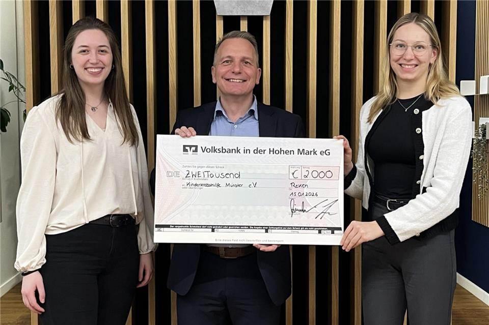 Rainer Schwital, Bankmitarbeiter und gleichzeitig Schatzmeister im Ehrenamt bei der Kinderkrebshilfe Münster, freut sich mit den Azubis über die Spende.