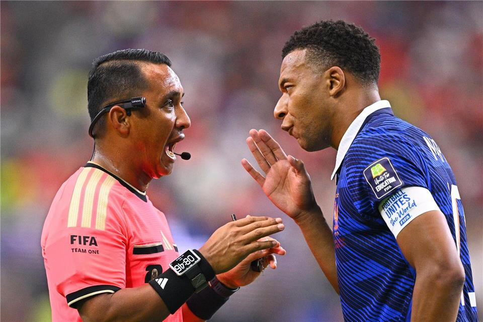 Redebedarf zwischen Schiedsrichter Ivan Barton und Kylian Mbappé.Tom Weller/dpa