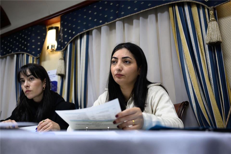 Reem Alabali Radovan (SPD, r), Bundesministerin für wirtschaftliche Zusammenarbeit und Entwicklung, und Pressesprecherin Aline Abboud besprechen im Zug nach Kiew das Reiseprogramm.Hendrik Schmidt/dpa