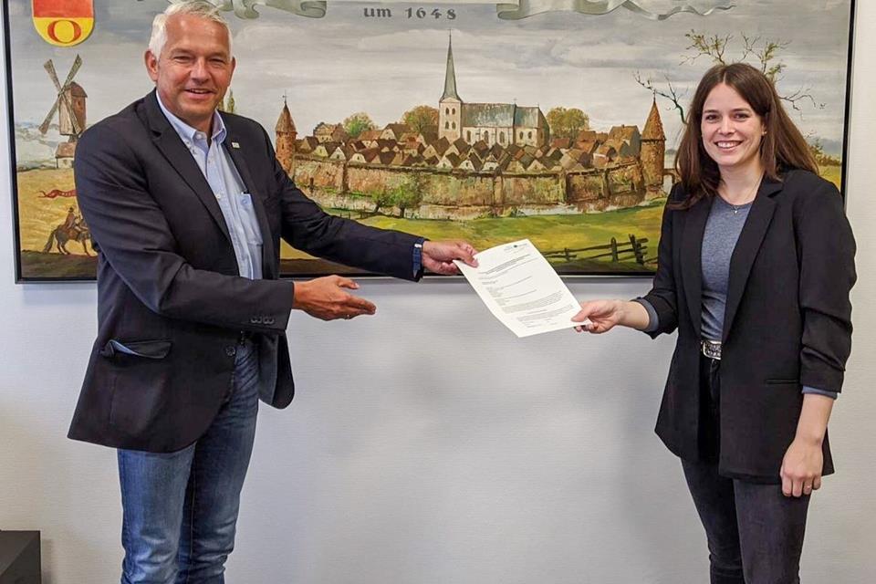 Regionalmanagerin Josephine Kißmer übergibt den Förderbescheid an Olfens Bürgermeister Wilhelm Sendermann. Hier sollen über das Regionalbudget zwei E-Scooter angeschafft werden.