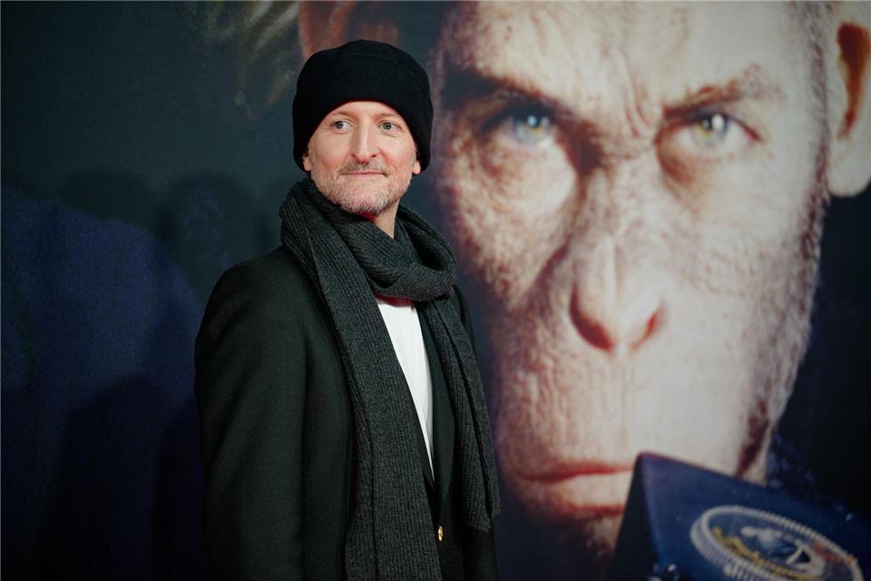 Regisseur Michael Gracey vor einem Bild seines Hauptdarstellers. (Archivbild)Henning Kaiser/dpa