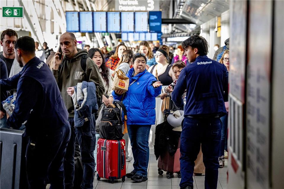 Reisende stehen Schlange am Serviceschalter der Fluggesellschaft KLM am Flughafen Schiphol. Robin Utrecht/ANP/dpa